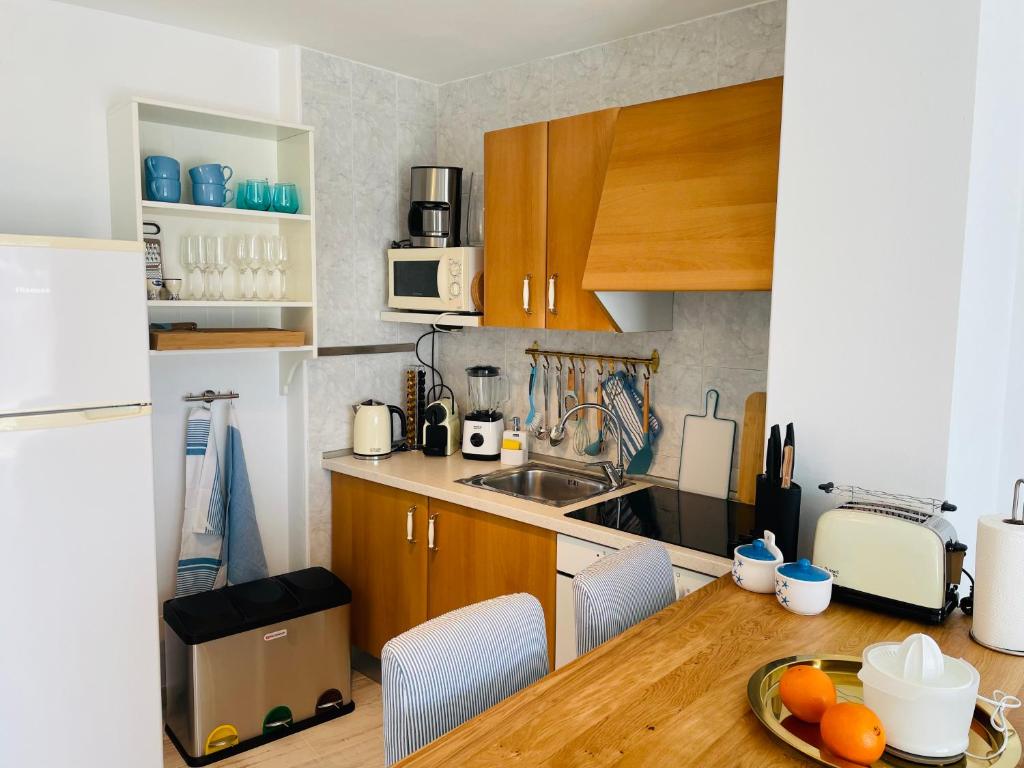 a kitchen with wooden cabinets and a table with oranges on it at Blue House Mallorca in Ses Salines