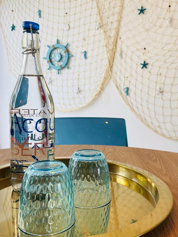 a bottle of coke and two glasses on a table at Blue House Mallorca in Ses Salines