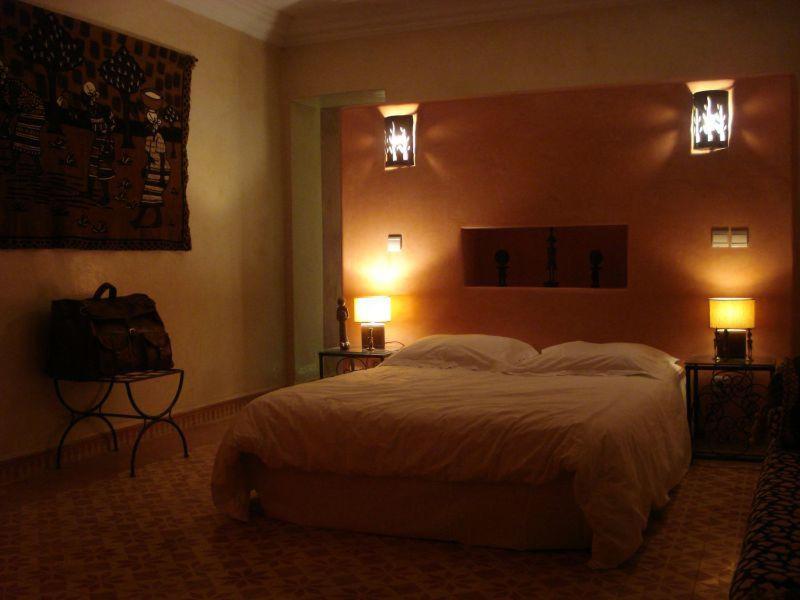 een slaapkamer met een bed en twee lampen aan de muur bij CHATEAU D'ORIENT in Essaouira