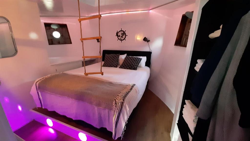 a small room with a bed with purple lights at De Coaster in Rotterdam