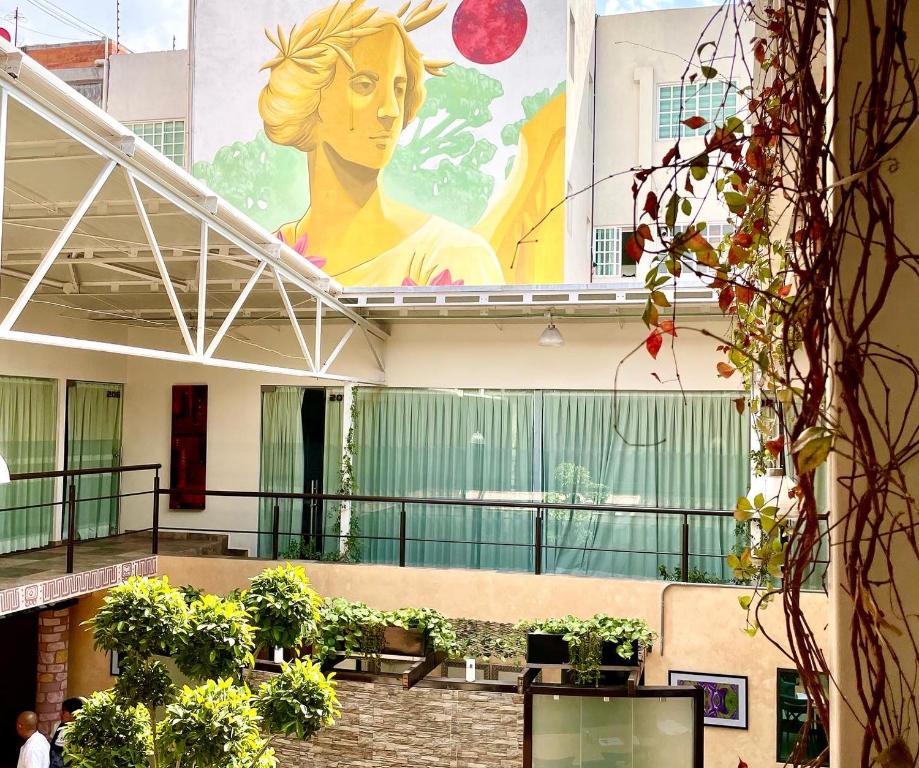 a large mural on the side of a building with plants at Downtown Treasure Place in Mexico City