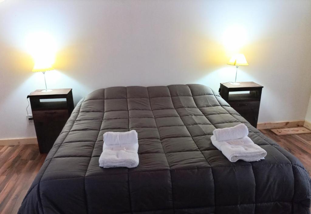 1 dormitorio con 1 cama grande y 2 mesitas de noche en La Cantonada en Caviahue