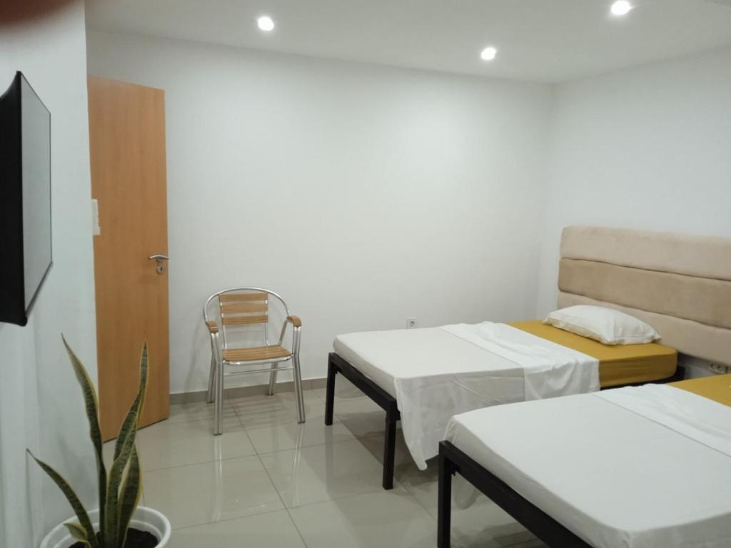Cette chambre comprend deux lits et une chaise. dans l'établissement Pull Up, à Praia