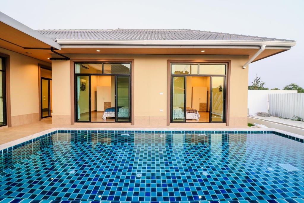 a villa with a swimming pool in front of a house at Modern Villa Hua Hin 华欣静家之泳池四合院 in Hua Hin