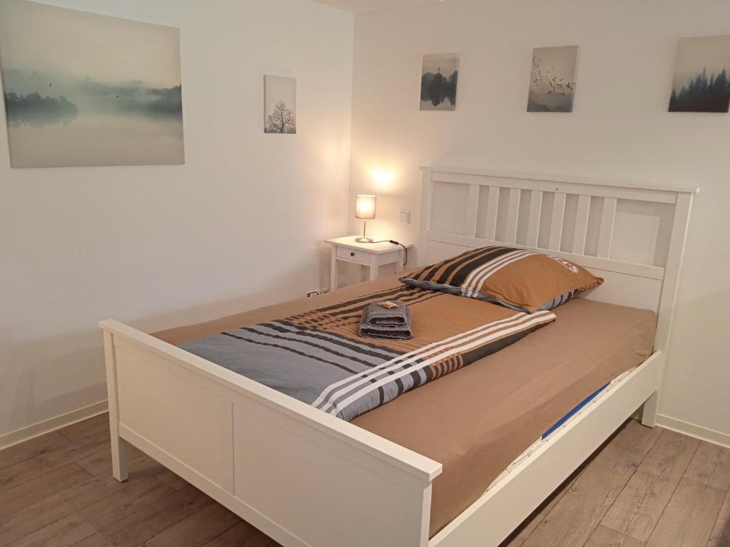 Un dormitorio con una cama blanca con una lámpara. en Ferienwohnung Jansen "Drei" en Bad Schwalbach