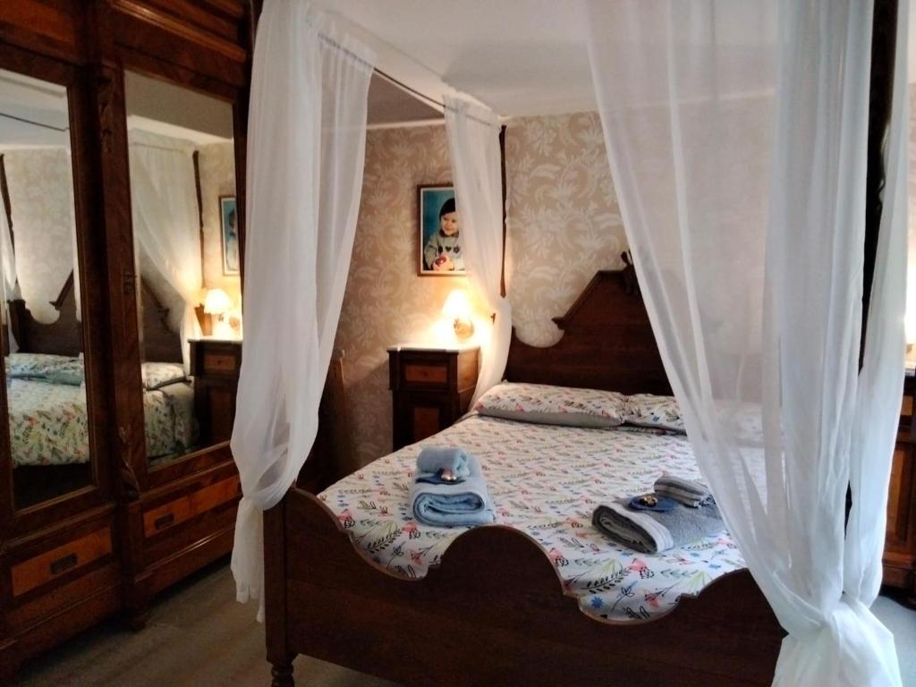 a bedroom with a canopy bed with towels on it at Sguardo sul lago in Trevignano Romano