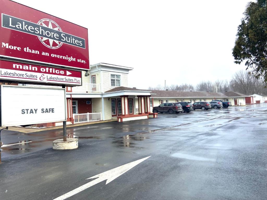 a parking lot with cars parked in front of a building at Lakeshore Suites in North Bay