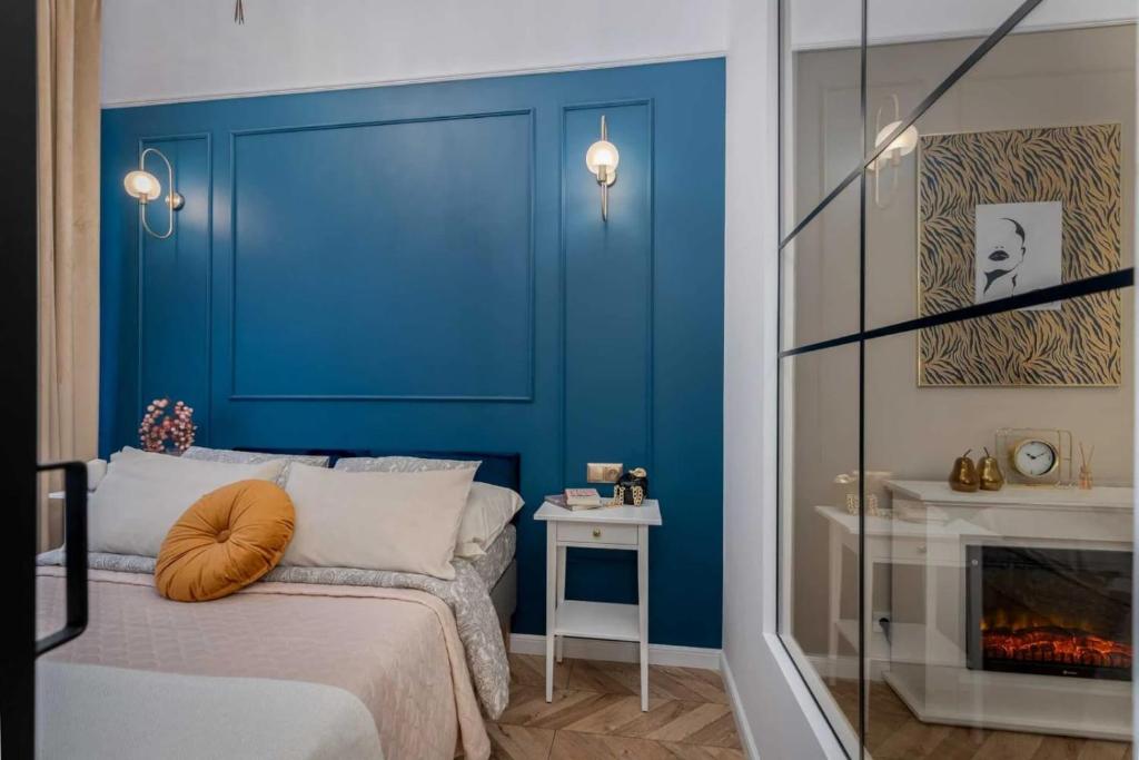 - une chambre bleue avec un lit et une cheminée dans l'établissement Olver Apartment, à Cracovie