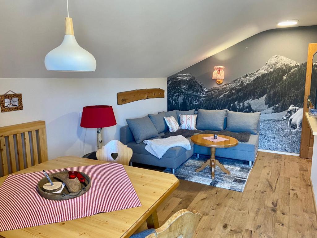 a living room with a blue couch and a table at Allgäu-Moni in Füssen