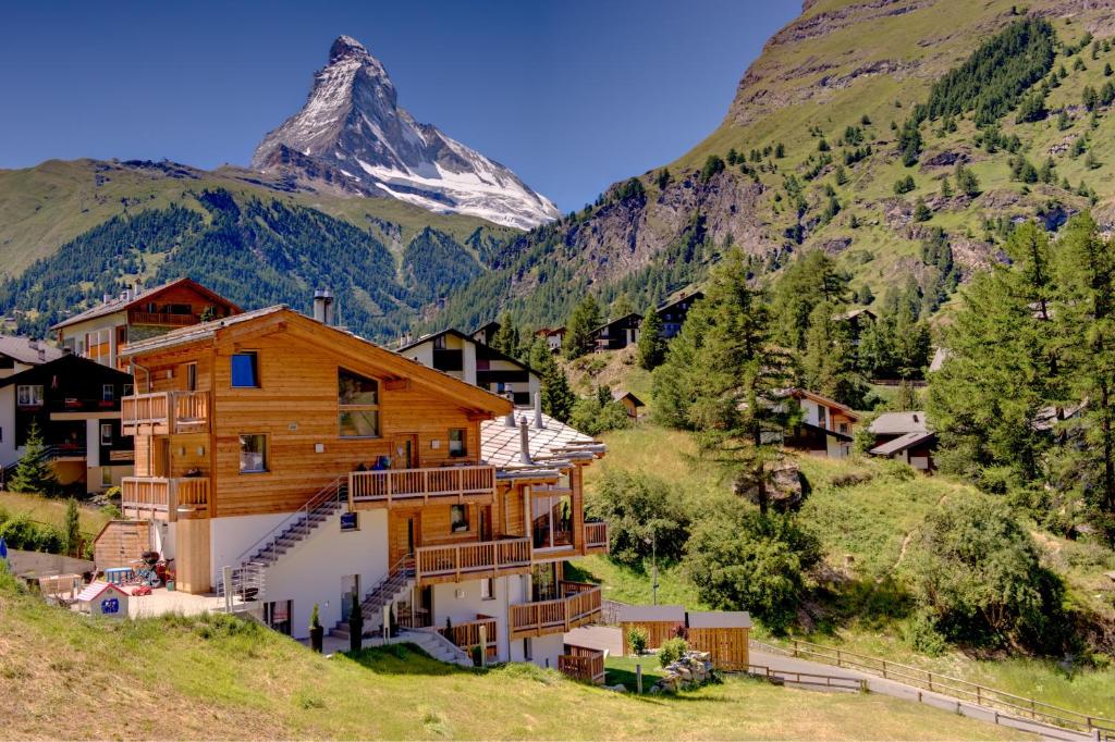 une maison dans les montagnes avec une montagne en arrière-plan dans l'établissement Angelina, à Zermatt