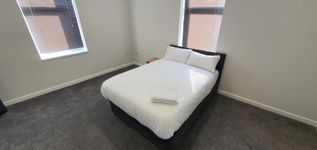 een slaapkamer met een bed met witte lakens en kussens bij APARTMENT in BARNSLEY CENTRAL in Barnsley