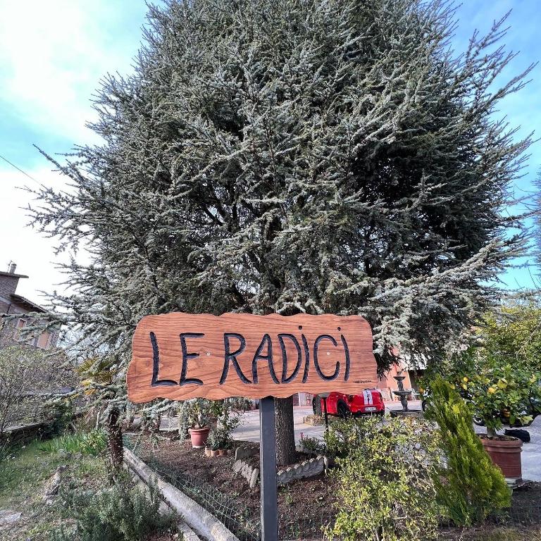 Znak, który czyta le radio przed drzewem w obiekcie LE RADICI w mieście Civitella dʼAgliano
