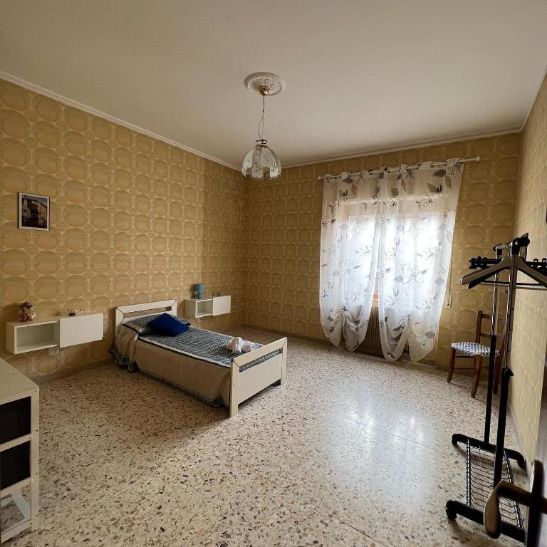 sypialnia z łóżkiem i żyrandolem w obiekcie LE RADICI w mieście Civitella dʼAgliano