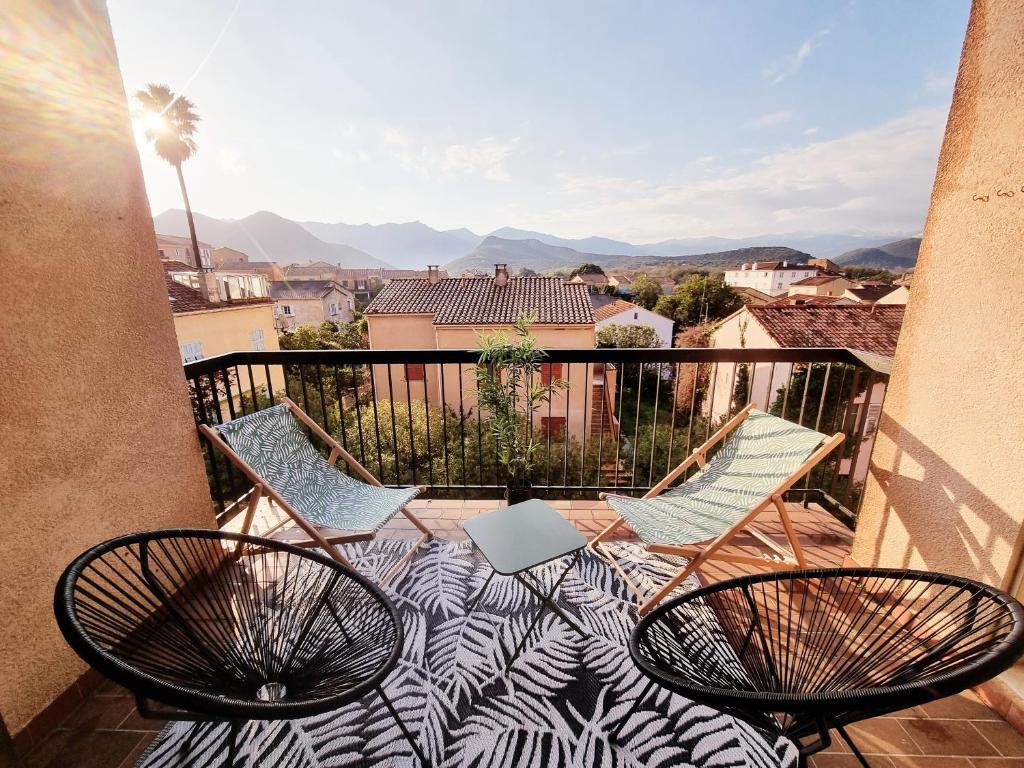 two chairs and a table on a balcony with a view at Bel appartement centre ville 3 chambres in Saint-Florent
