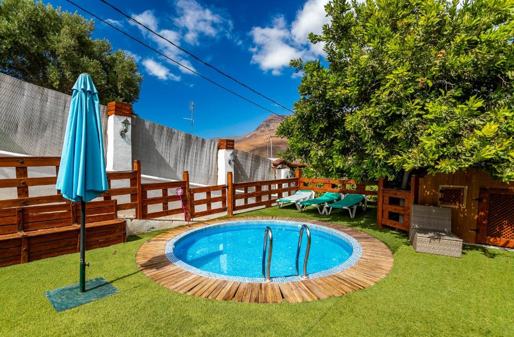 - une piscine avec un parasol dans la cour dans l'établissement Casa el pinillo, à San Nicolás