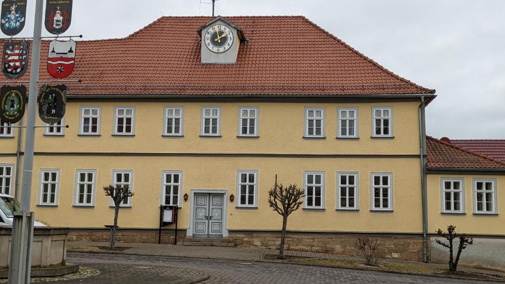 un gran edificio amarillo con un reloj encima en Quartier Goldener Löwe en Günthersleben