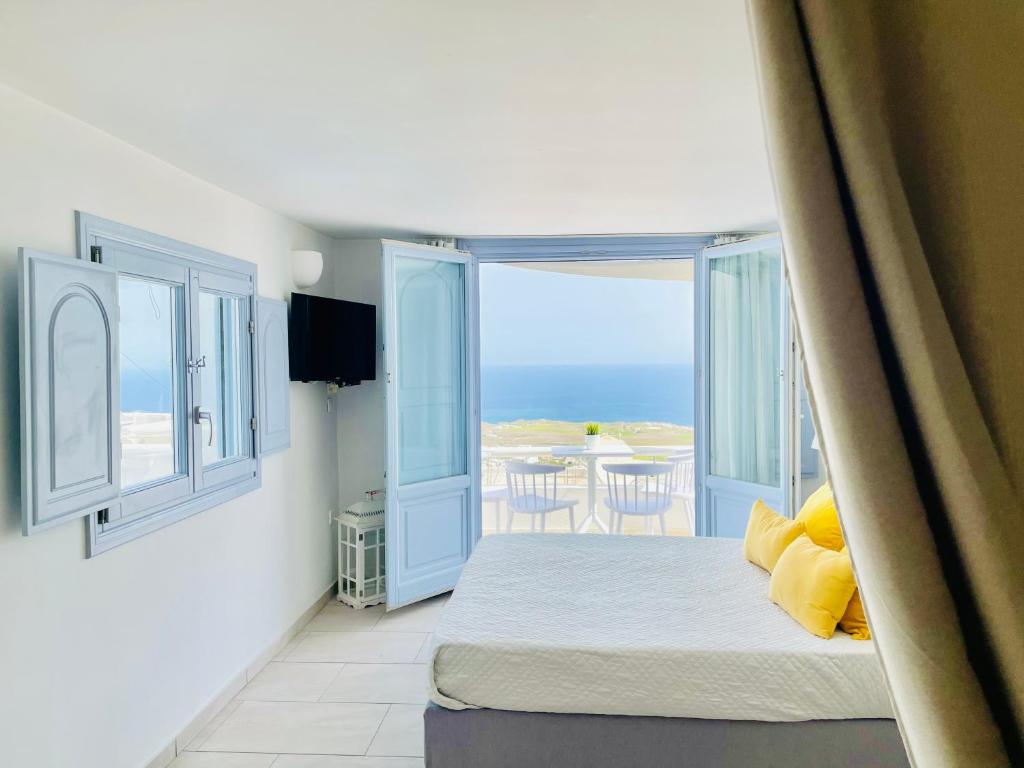 a bedroom with a bed with a view of the ocean at Elkaza Villas in Fira