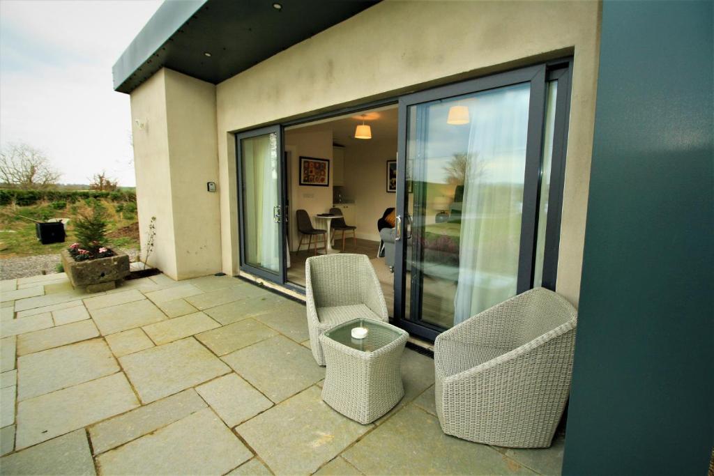 a screened in porch with two chairs and a table at The Shepherd's Lodge in Tullyallen