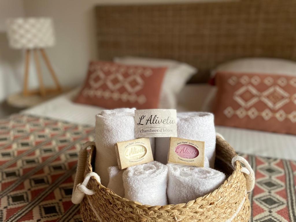 a basket filled with towels and candles on a bed at L'ALIVETU, Chambres d'hôtes in Bastelicaccia