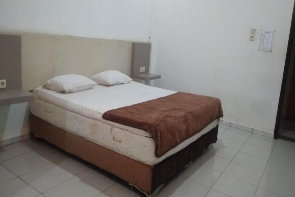 een slaapkamer met een groot bed in een kamer bij OYO 91097 Hotel Atika in Sarolangun