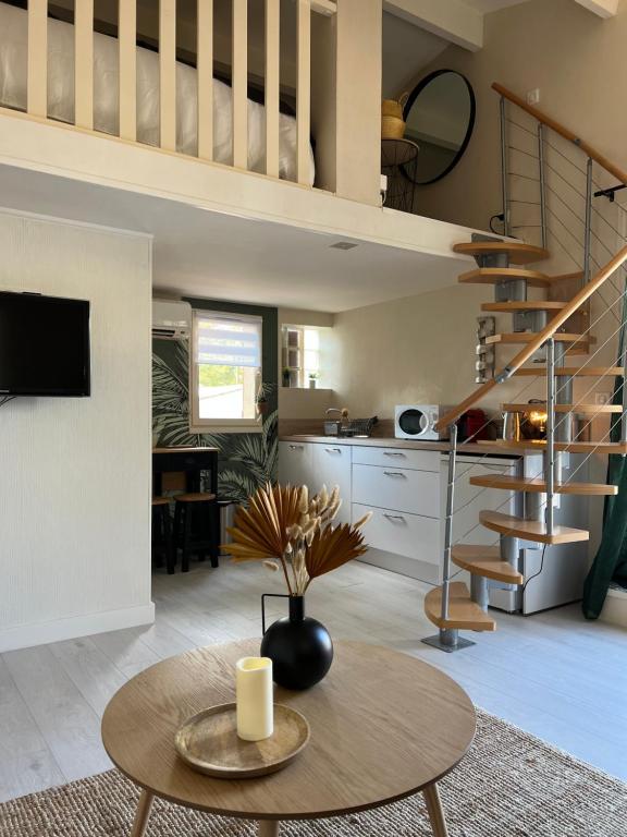 een woonkamer met een wenteltrap en een tafel bij L échappée belle Coquet appt proche du village naturiste , terrasse et parking in Cap d'Agde