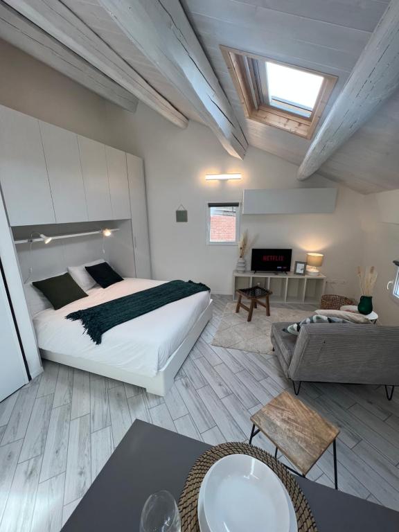 ein Schlafzimmer mit einem Bett und ein Wohnzimmer in der Unterkunft [Ferrara Centro - WABI APT] in Ferrara