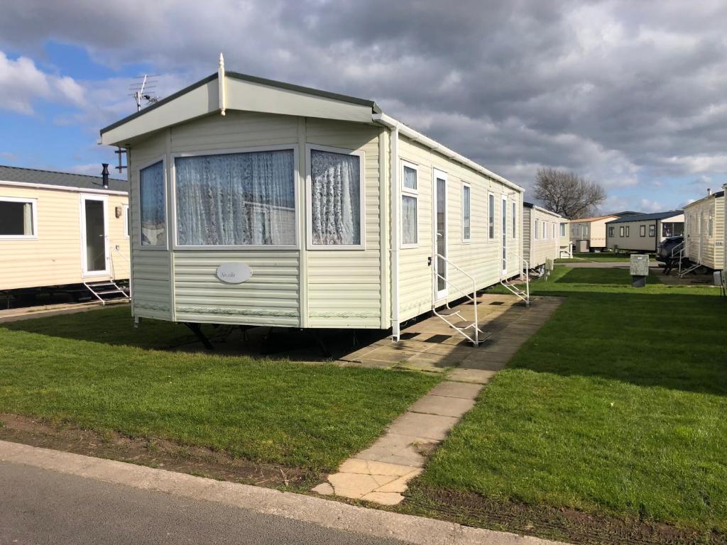 a row of mobile homes parked in a yard at Lovely 3 bedroom 8 berth caravan in Rhyl in Rhyl