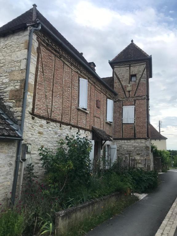 un vieux bâtiment en briques avec une tourelle dans une rue dans l'établissement Le pigeonnier maison de caractère logement 4 personnes La maisonnette rénovée logement 2 personnes, à Floirac