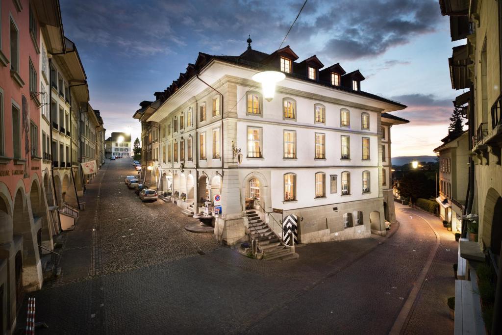 duży biały budynek z oświetleniem na górze w obiekcie Hotel Stadthaus w mieście Burgdorf