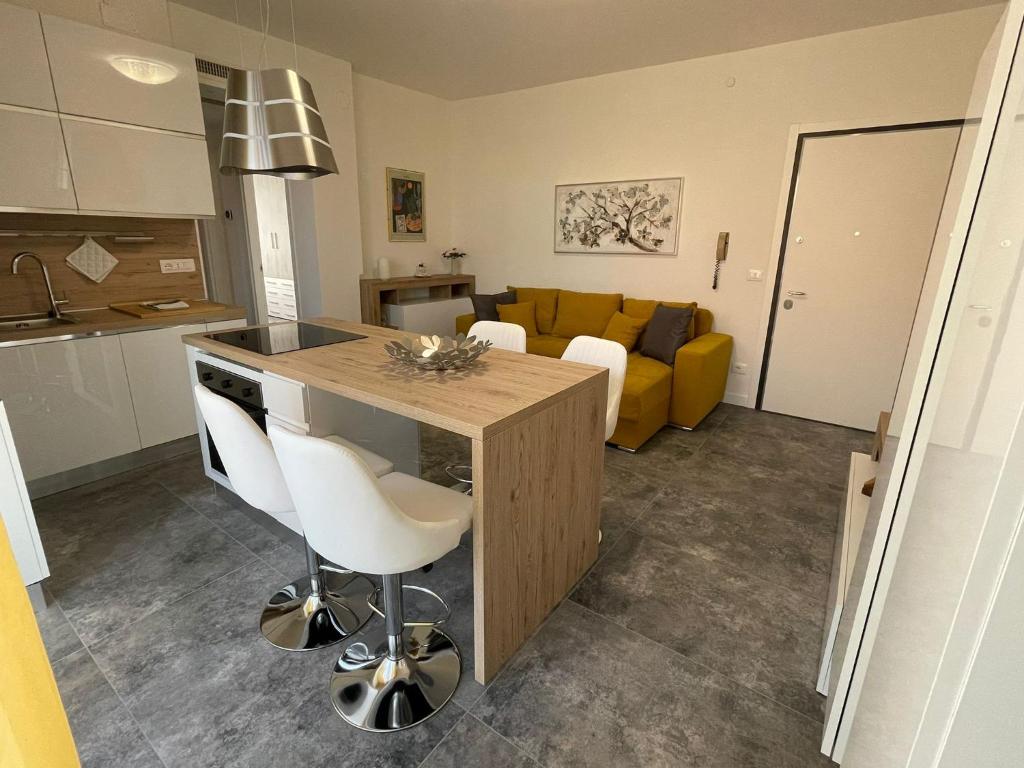 a kitchen and living room with a yellow couch at Magic Apartments in Bardolino