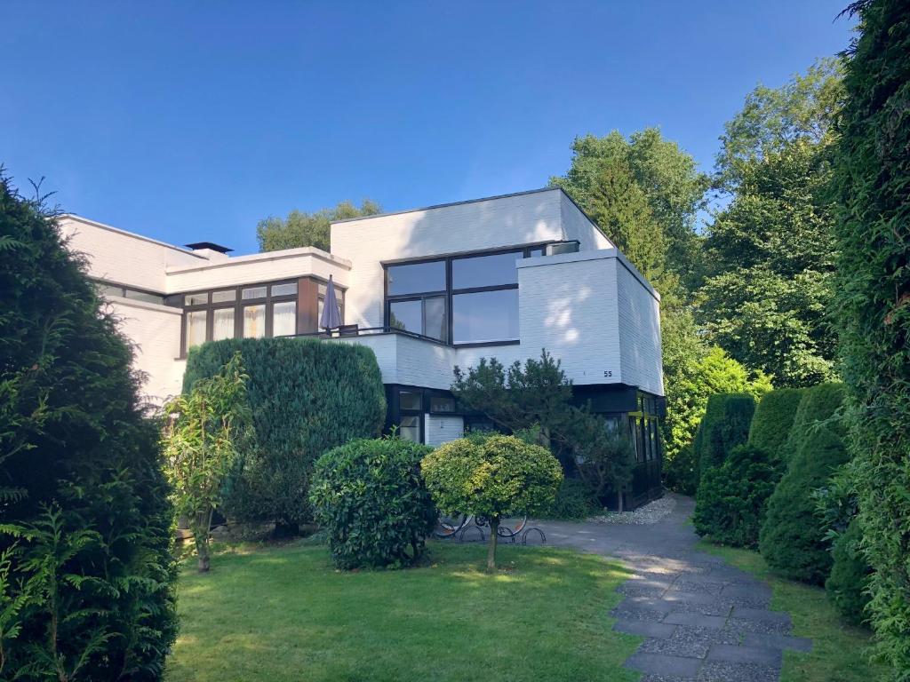 a large white house with bushes and trees at Ferienwohnung Ostsee Timmendorferstrand in Timmendorfer Strand