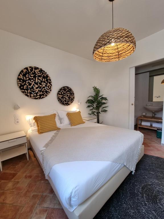 法魯的住宿－Casa Algarbe，一间卧室配有一张大白色的床和两个吊灯
