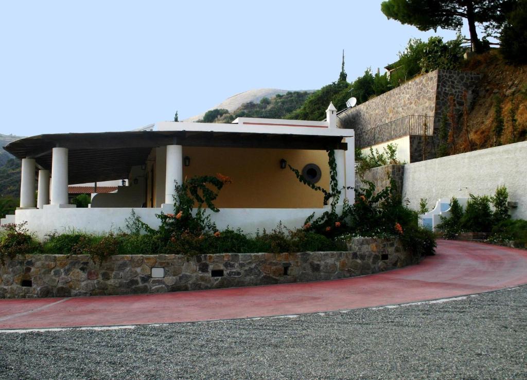 una casa con una pared de piedra y un camino de entrada en Case Vacanze Valle, en Lipari