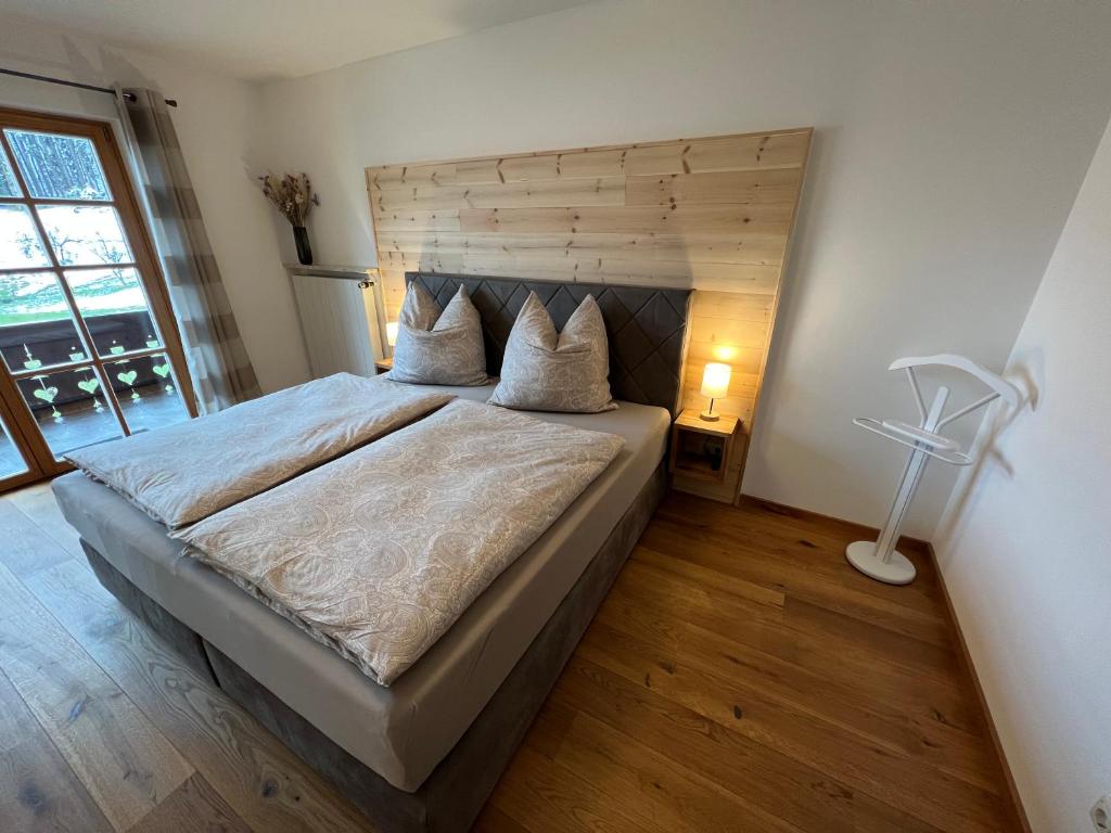 a bedroom with a large bed with a wooden headboard at Beim Mühltaler in Schleching