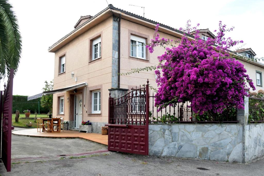 a house with a fence with purple flowers on it at LA BUGANVILLA in Gijón