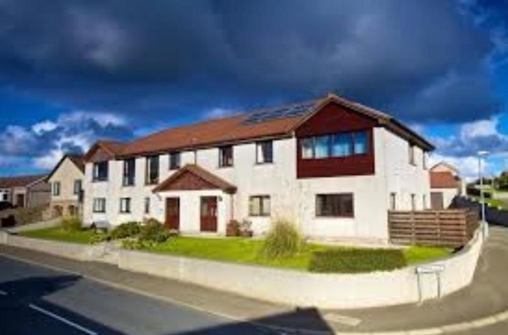 a large white building with a brown roof at Royal Oak Guesthouse in Orkney