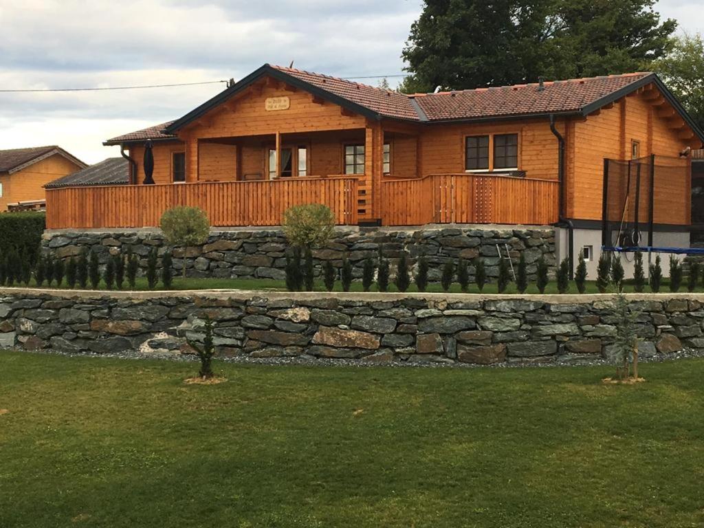 a house with a stone retaining wall and a fence at Ferienhaus Altmann 1 in Sankt Magdalena