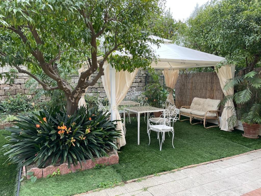 a garden with a table and chairs under a white canopy at Le Dimax in Sant'Agnello