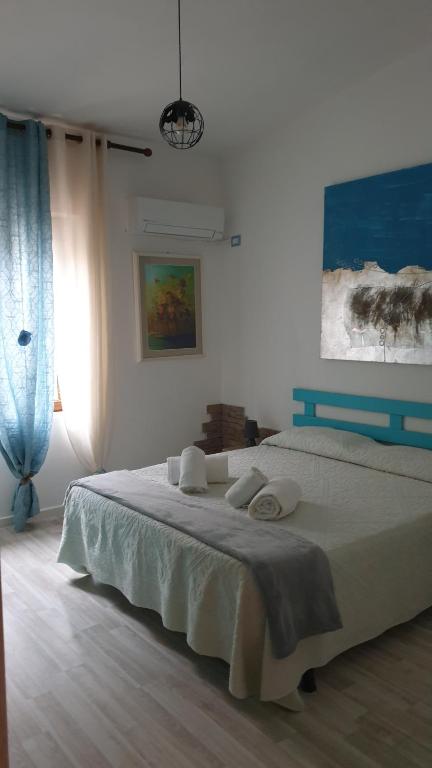 a bedroom with a large bed with white sheets at B&B Cala Luna in Cala Gonone