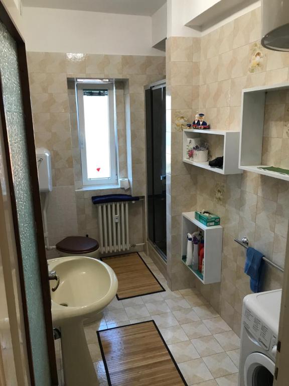ein kleines Bad mit einem Waschbecken und einem WC in der Unterkunft Muggia Studio 2 in Muggia