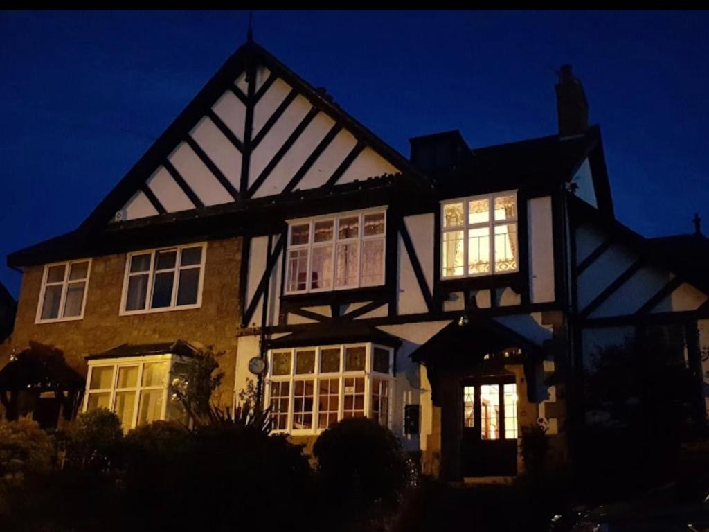 una casa en blanco y negro con sus luces encendidas en Braehead Guest House, en Inverness