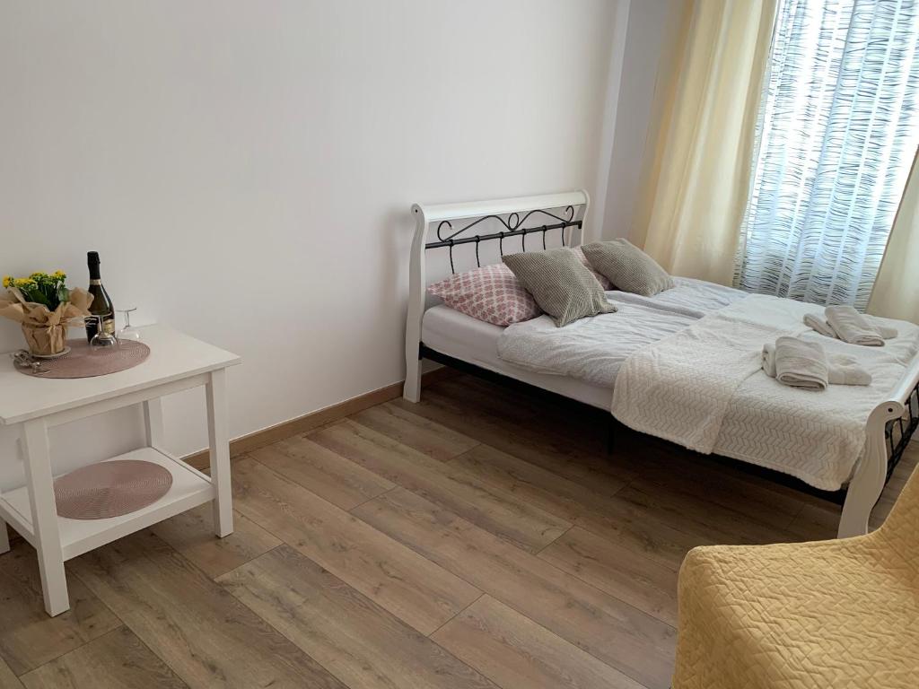 een slaapkamer met een bed, een tafel en een raam bij Sweet apartament in Tarnowskie Góry