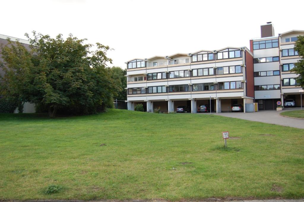 a building with a sign in the grass in front of it at Kalifornia258 in Schönberg in Holstein