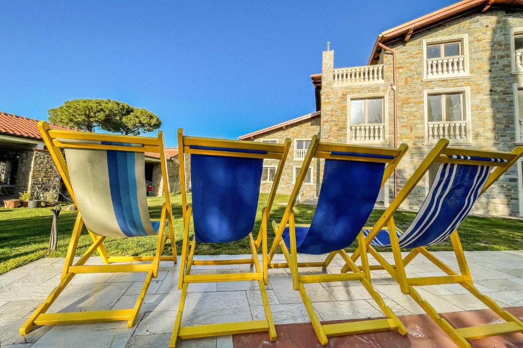 dos sillas amarillas y azules sentadas en un patio en Da Ilaria piano terra di villa con piscina e parcheggio, en Grosseto