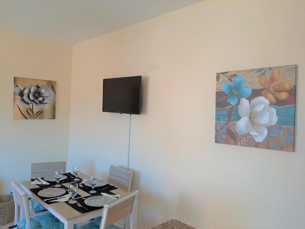 d'une salle à manger avec une table et une télévision murale. dans l'établissement Precioso apartamento con ascensor a 80 metros del mar, à Torrevieja