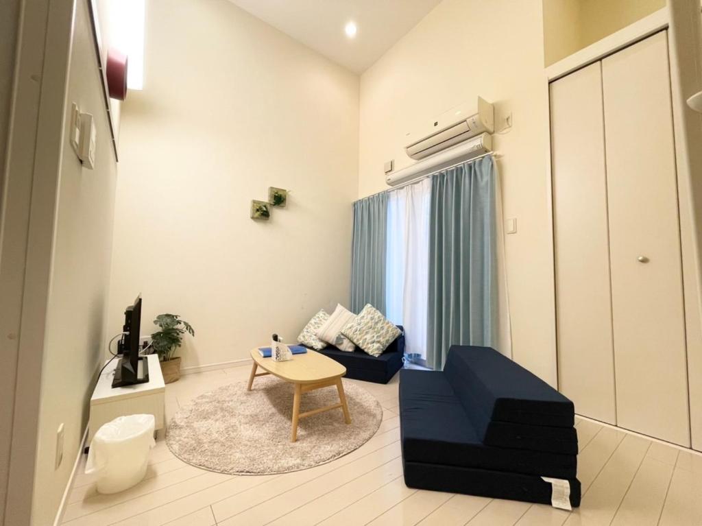 - un salon avec un canapé bleu et une table dans l'établissement i home Tsubogawa / Vacation STAY 53026, à Naha