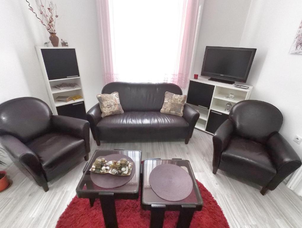 a living room with leather furniture and a flat screen tv at Apartment Milijana in Subotica