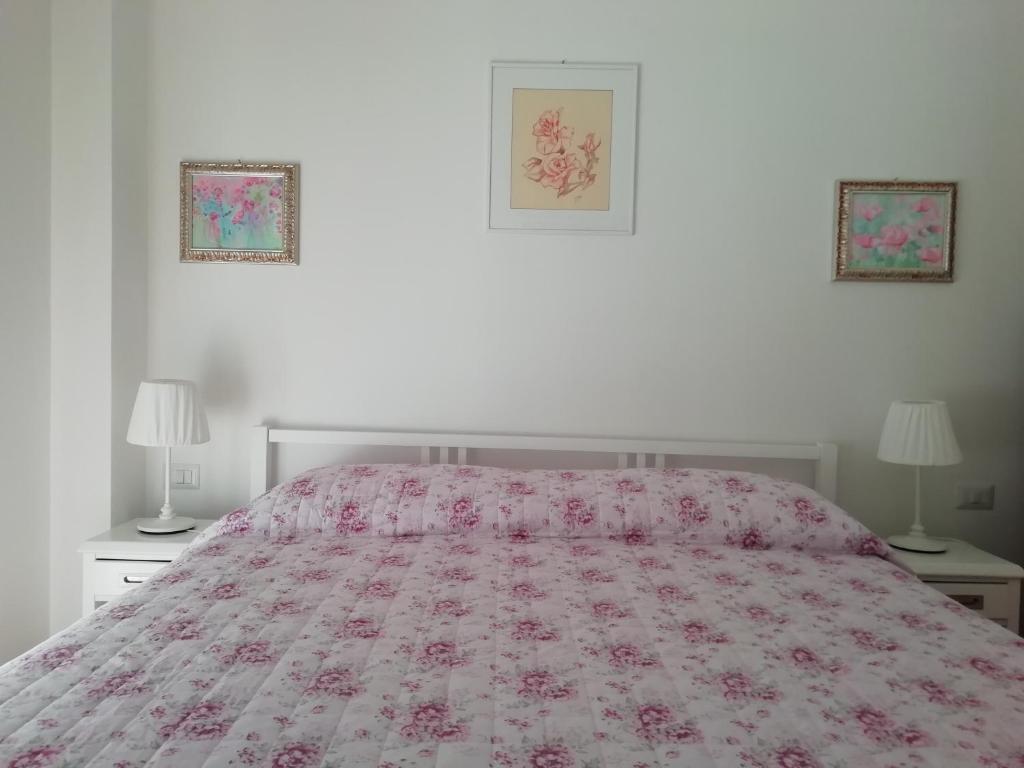 1 dormitorio con 1 cama con colcha rosa y 2 lámparas en La Vie En Rose en Rapallo
