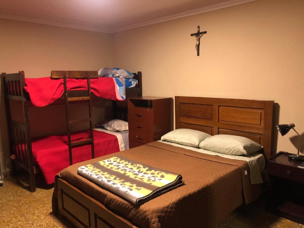 een slaapkamer met 2 stapelbedden en een kruis aan de muur bij Ballivian in Tarija