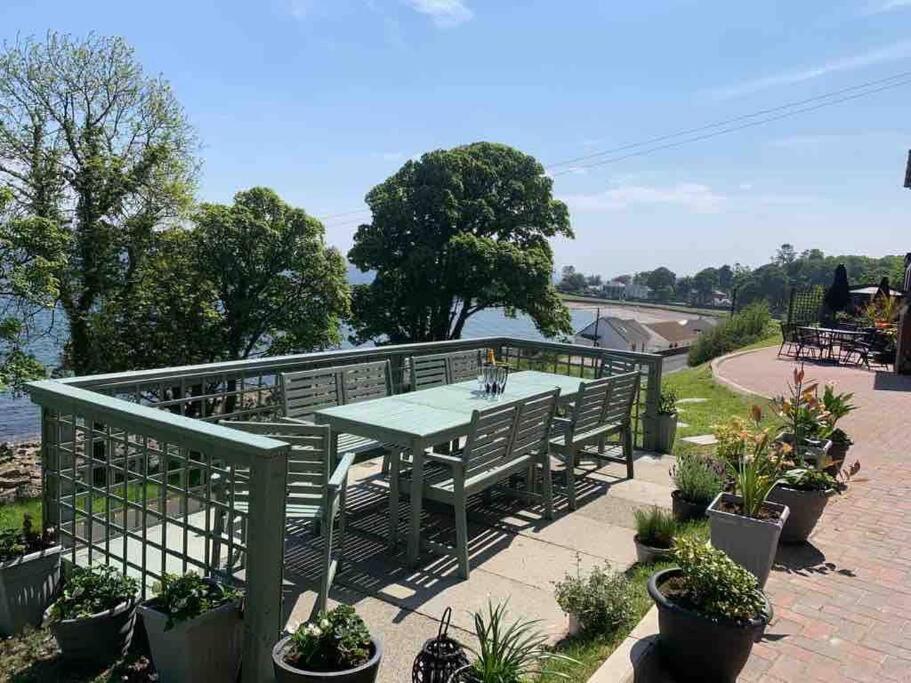 a green picnic table with benches and plants at Chandlers Apartment in Ascog